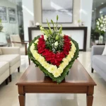 Los arreglos funebres con rosas rojas en forma de corazón son un homenaje profundo que expresa amor eterno, respeto y recuerdo sincero.