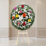 Corona floral con gerberas de colores para luto y condolencias
