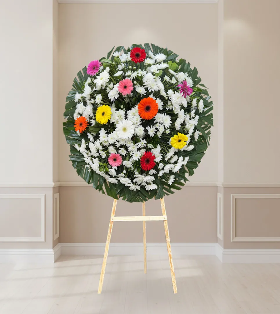 Corona floral con gerberas de colores para luto y condolencias